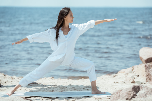 What is the heart chakra pics:  Asian women in a yoga pose on the beach.