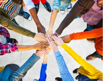 The benefits of tithing can include improving relationships and creating new relationships.  Here, people put their hands in a circle.